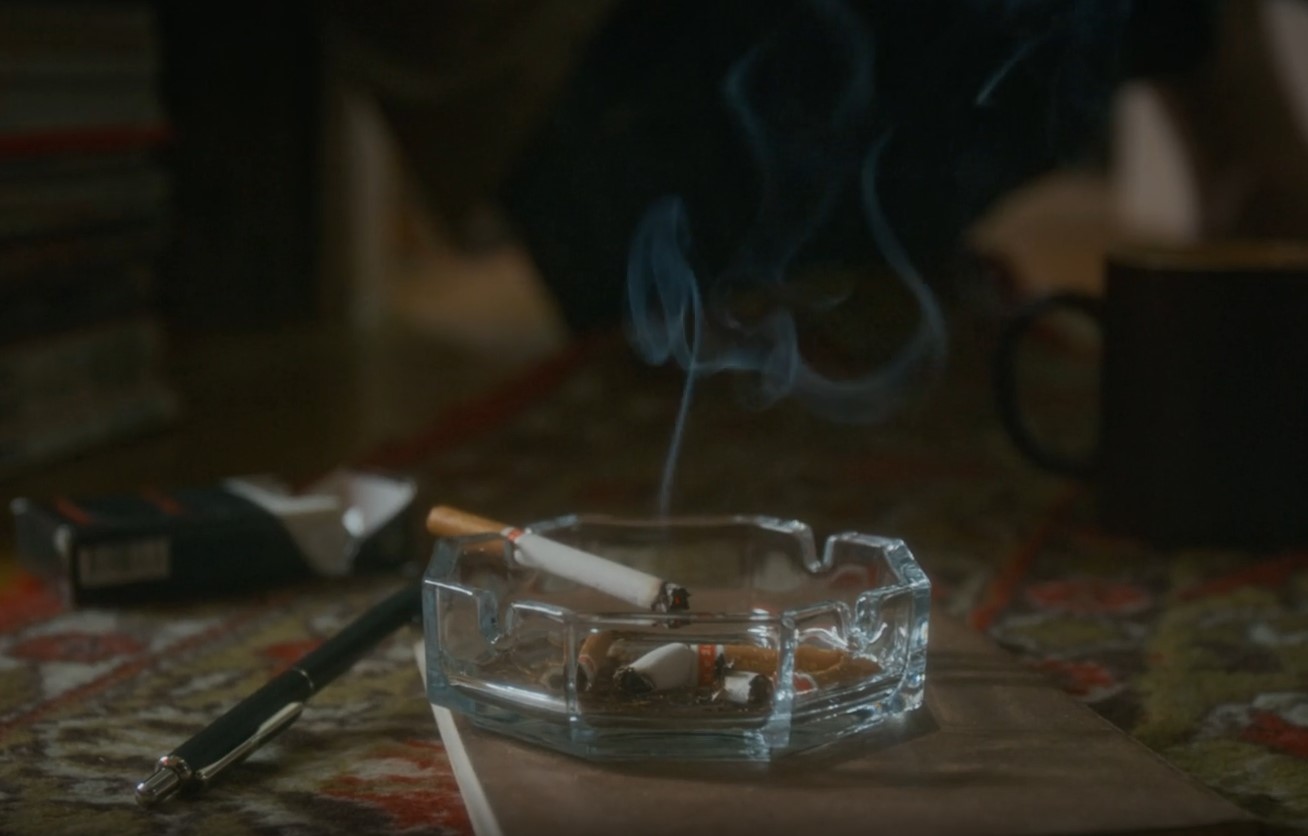 A cigarette burning in the ashtray